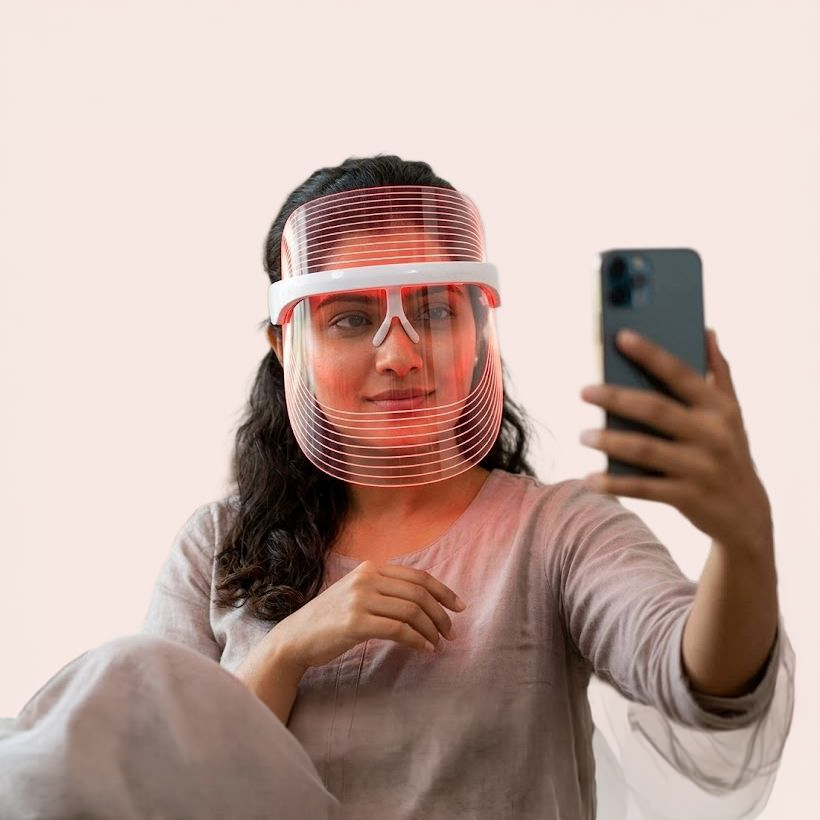Woman using Zivora LED face mask at home